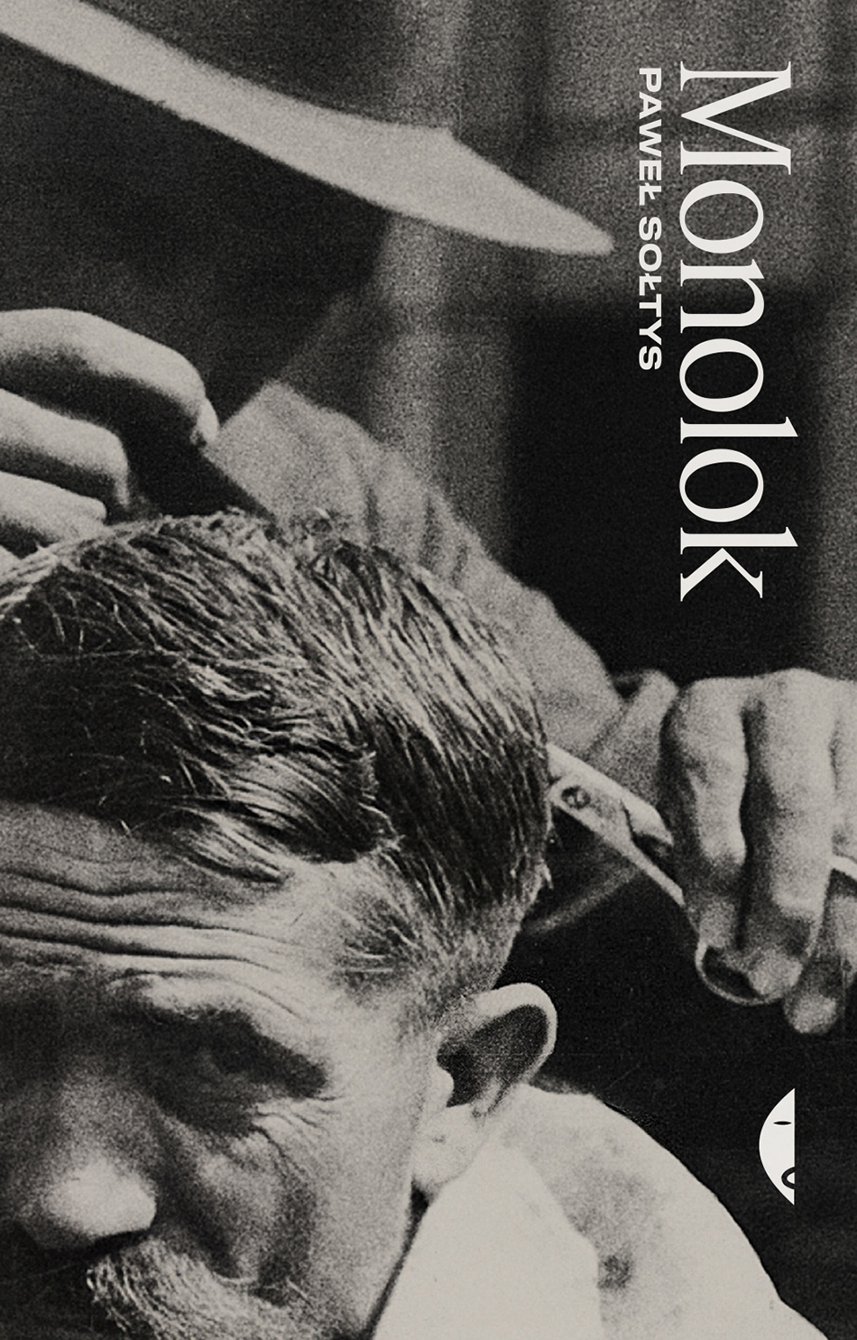 czarno-biała okładka książki przedstawia mężczyznę strzyżonego przez fryzjera w kapeluszu