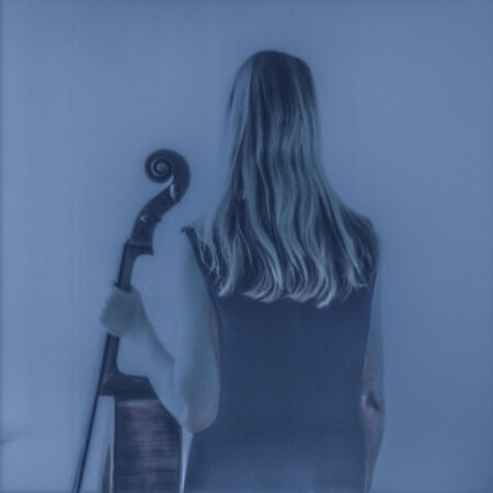 okładka w kolorach błękitu przedstawia artystkę stojącą tyłem trzymającą w ręku wiolączelę