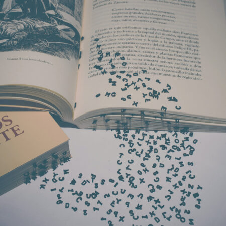 grafika przedstawia literki wysypujące się z otwartej książki