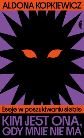 Fioletowa okładka książki przedstawia czarny geometryczny kształt z pomarańczowymi oczami